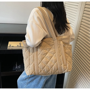 Détail du grand sac cabas matelassé avec motif à losanges porté à l'épaule