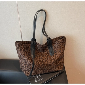 Détail du sac cabas en daim imprimé léopard avec de fines lanières en cuir noir