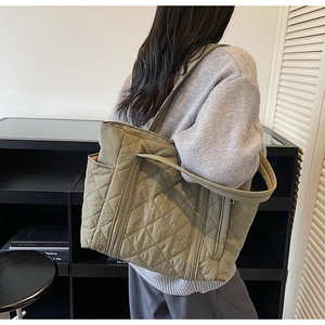 Détail du sac fourre-tout matelassé vert olive avec motif en losange et poche latérale sur modèle