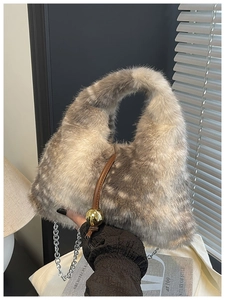 Détail du sac à main en fausse fourrure avec chaîne argentée et élégante et breloque boule dorée