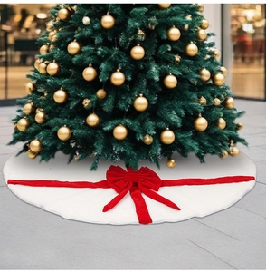 Détail de jupe de sapin de Noël en peluche blanche avec nœuds festifs en velours rouge