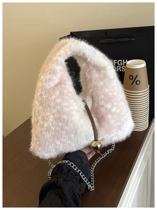 Détail de la texture en peluche rose avec boule dorée et bandoulière sur une table