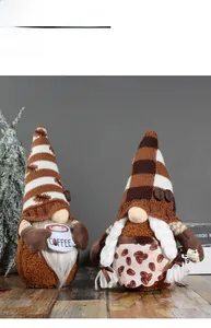 Detail of two coffee-themed gnomes with knitted hats and coffee cup on a wooden surface