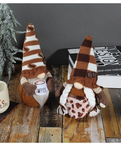 Detail of coffee theme gnome plush dolls with knitted hats and coffee cup on wooden floor