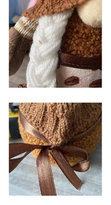 Detailed macro view of handmade knitted dwarf doll with white braids and brown satin bow