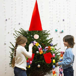 Christmas gnome tree topper set with red felt hat and mittens on a decorated tree