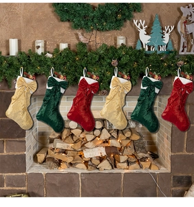 Close-up of sparkling sequin Christmas stockings with bows hanging on a festive fireplace
