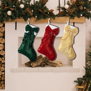 Three-piece sequin Christmas stockings in red, green, and gold with large bows for fireplace