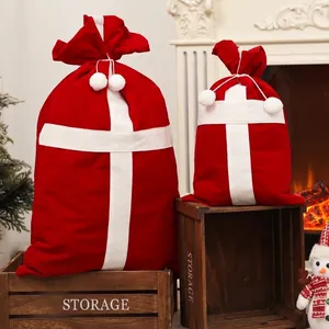 Flocked red Christmas candy gift bags with white pom-poms in a warm festive home setting