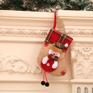 Linen Christmas stocking with 3D snowman and red-green plaid cuff hanging on white fireplace
