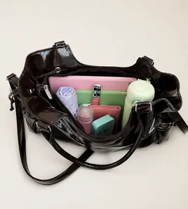 Top view showing spacious interior of dark brown patent leather tote with daily essentials
