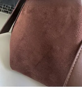 Detail shot of brown suede crossbody bag showing soft texture and neat stitching