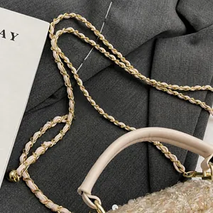 Dettaglio della trama in tweed intrecciato con paillettes argento e tracolla dorata