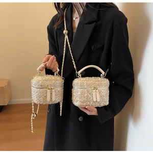 Dettaglio della mini borsa a tracolla in tweed beige con catena dorata e manico