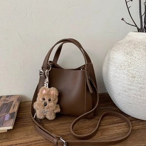 Retro dark brown litchi pattern bucket bag with cute plush dog pendant and crossbody strap