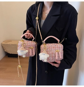 Detail van roze tweed mini-tas met gouden kettingriem en een zachte pluche hanger