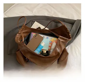 Spacious interior of brown faux leather tote bag showing tablet and cosmetics