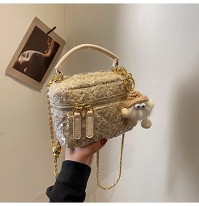 Detail van glitter tweed mini emmer tas met gouden ketting en pluche sleutelhanger