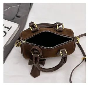 Detail view of the brown suede pillow bag interior and its stylish bow charm decoration
