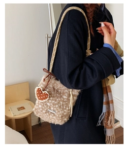 Détail d'un sac seau en peluche tachetée marron avec bandoulière corde et pendentif cœur