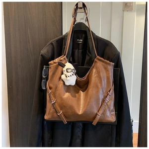 Brown vintage leather tote bag with silver buckle detail and cute plush puppy charm