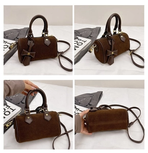 Detail view of dark brown suede pillow bag showing smooth stitching and metal rivets