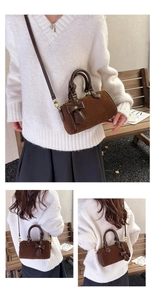 Detailed macro view of dark brown suede boston bag with leather bow and golden hardware