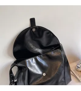 Detail view of the black hobo bag with a functional magnetic buckle closure and soft lining