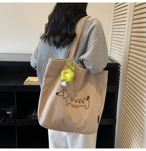 Detalle de bordado de perro salchicha en bolso tote de pana beige con colgante