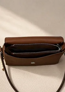 Interior view of brown suede crossbody bag showing large compartment and metal zipper