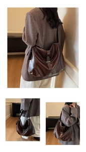 Detail view of deep brown vintage leather bag showing metal buckle and smooth texture