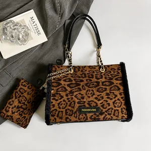 Detail view of leopard print tote bag with plush trim, gold chain, and mini pouch