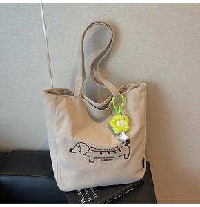 Detalle del bolso tote de pana beige con bordado de perrito y adorno de flor