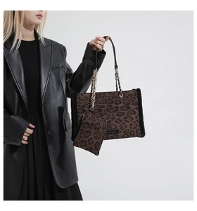 Detail of leopard print tote bag with black faux fur trim and gold chain shoulder strap