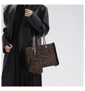 Detailed close-up of leopard print tote bag with plush trim and metal chain strap