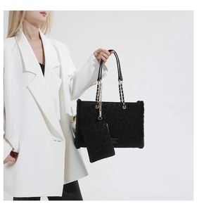 Detail of black leopard embossed tote bag with plush trim and metal chain strap