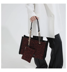 Detailed close-up of leopard print plush tote bag with gold chain and black fur trim