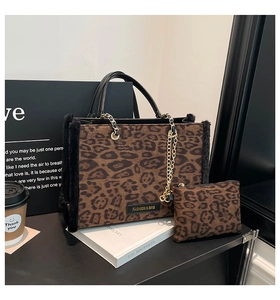 Detail of leopard print tote bag with black faux fur trim and gold chain strap