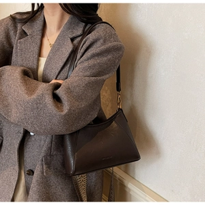Primer plano detallado de bolso de cuero marrón oscuro con herrajes metálicos vintage