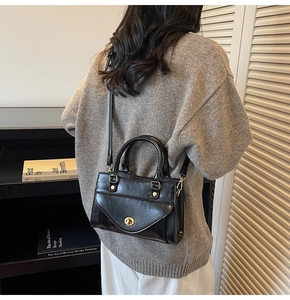 Klassieke zwarte vintage crossbody tas met gouden draaisluiting en glanzend PU-leder