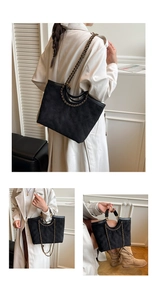 Close-up of black quilted tote bag featuring metal chain strap and matte texture finish