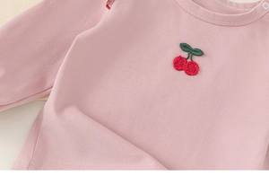 Detail of pink cotton long-sleeve tee with high-quality cherry embroidery and shoulder buckles