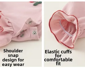 Pink cotton baby shirt detail with shoulder snaps and ruffle trim on elastic cuffs