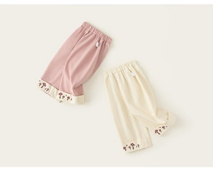 Dettaglio di pantaloni in cotone per bambini con vita elastica e stampa a fungo