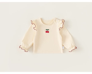 Detail of cream cotton girls top with red ruffle trim and embroidered cherry pattern