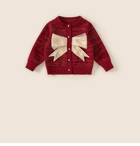 Dettaglio del cardigan rosso da bambina con grande fiocco beige e bottoni perlati