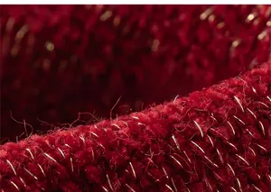 Dettaglio ravvicinato del tessuto rosso a maglia con fili dorati festivi del cardigan