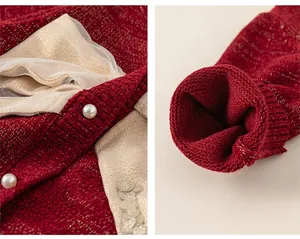 Dettaglio del cardigan rosso in maglia con fiocco in rete, bottoni perlati e polsini