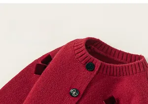 Dettaglio del cardigan in maglia bordeaux per bambina con fiocchi di velluto e bottoni farfalla