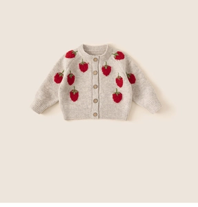 Detail van gebreid vest met rode aardbeiborduursels en houten knopen voor kids